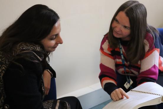 two people talking and reading a booklet